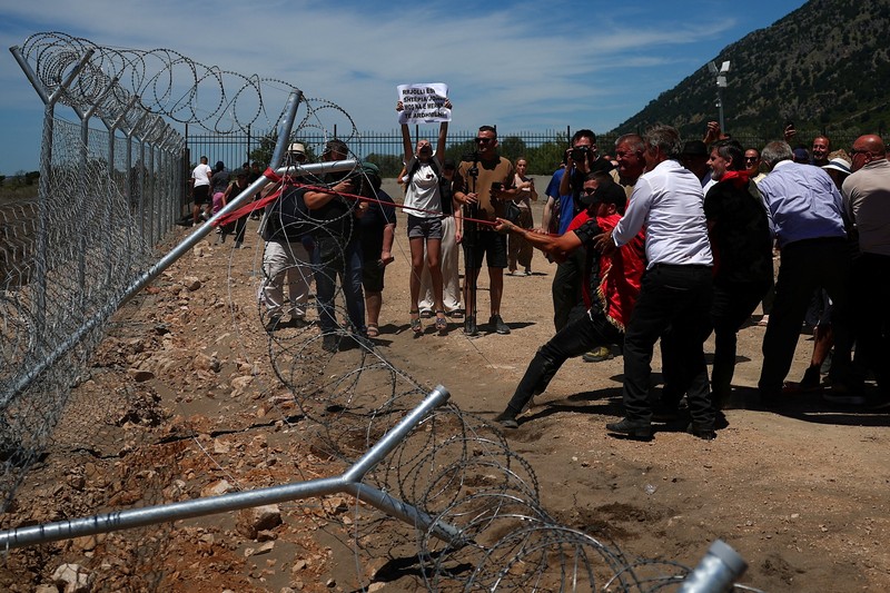 Para pengunjuk rasa yang mengatakan tanah mereka telah diambil secara tidak adil, merobohkan pagar tempat resor wisata akan dibangun di tepi pantai Adriatik, di Rrjoll, dekat Shkodra, Albania, 13 Juni 2026. (REUTERS/Florion Goga)