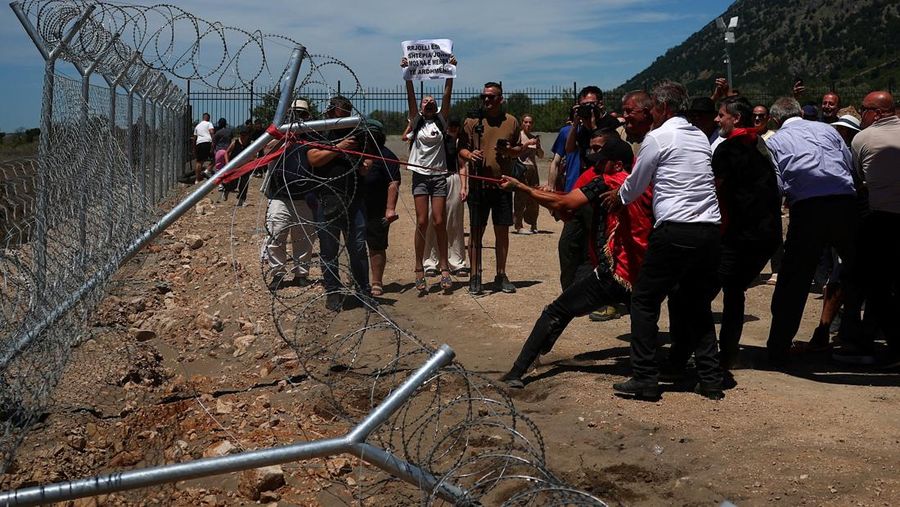 Para pengunjuk rasa yang mengatakan tanah mereka telah diambil secara tidak adil, merobohkan pagar tempat resor wisata akan dibangun di tepi pantai Adriatik, di Rrjoll, dekat Shkodra, Albania, 13 Juni 2026.