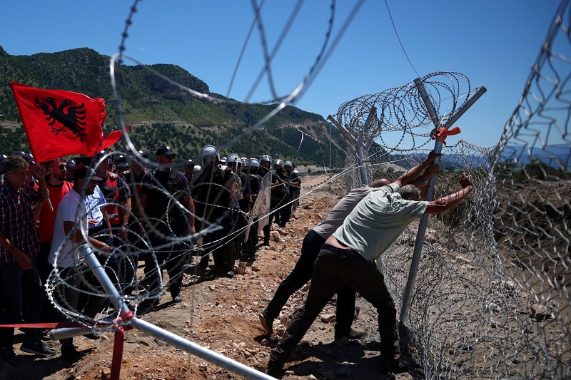 Para pengunjuk rasa yang mengatakan tanah mereka telah diambil secara tidak adil, merobohkan pagar tempat resor wisata akan dibangun di tepi pantai Adriatik, di Rrjoll, dekat Shkodra, Albania, 13 Juni 2026. (REUTERS/Florion Goga)