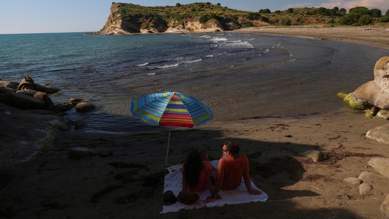 Para wisatawan duduk di teluk di Kawasan Lindung Vjosa-Narta, tempat sebuah resor mewah direncanakan oleh sebuah perusahaan yang terkait dengan menantu Donald Trump, Jared Kushner, di Zvernec dekat Vlora, Albania, 9 Juni 2026.