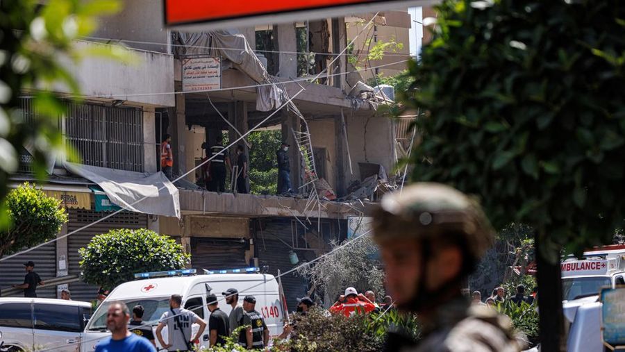 Seorang perwira tentara Lebanon berdiri sementara petugas polisi dan personel darurat bekerja di lokasi serangan Israel di pinggiran selatan Beirut, Lebanon, 14 Juni 2026.