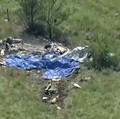Puing-puing pesawat tergeletak di lapangan di sebelah Bandara Memorial Butler setelah sebuah pesawat yang membawa penerjun payung jatuh di Butler, Missouri, AS, pada 14 Juni 2026, dalam gambar diam dari video. (ABC Affiliate KMBC via REUTERS)