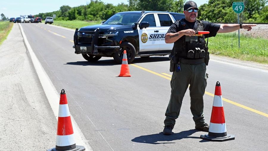 Seorang deputi sheriff Bates County mengarahkan lalu lintas menjauhi jalan menuju Bandara Memorial Butler setelah sebuah pesawat yang membawa penerjun payung jatuh di Butler, Missouri, AS, 14 Juni 2026.