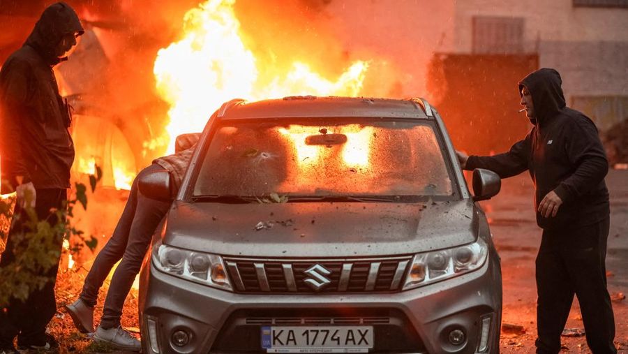 Residents try to move a car from a site of a Russian missile and drone strikes, amid Russia's attack on Ukraine, in Kyiv, Ukraine June 15, 2026. REUTERS/Alina Smutko     TPX IMAGES OF THE DAY