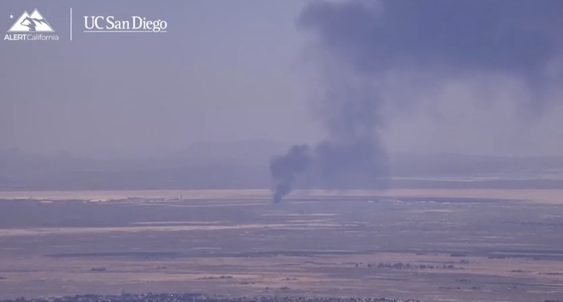 Asap mengepul dari bagian yang menghitam dari Pangkalan Angkatan Udara Edwards setelah jatuhnya pesawat pembom B-52 Angkatan Udara AS di Edwards, California, AS, 15 Juni 2026. (via REUTERS TV)