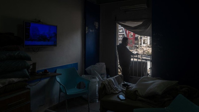 Youssef Fares, 90, whose home of more than 70 years, was reportedly damaged by an Israeli airstrike, stands at the window of a hospital room where he has taken shelter, overlooking buildings damaged by Israeli strikes, following a deal between the U.