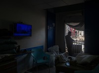 Youssef Fares, 90, whose home of more than 70 years, was reportedly damaged by an Israeli airstrike, stands at the window of a hospital room where he has taken shelter, overlooking buildings damaged by Israeli strikes, following a deal between the U.