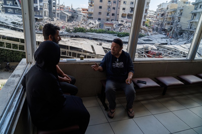 Youssef Fares, 90, whose home of more than 70 years was damaged in an Israeli airstrike, stands at the window of a hospital room where he has taken shelter, overlooking buildings damaged by Israeli strikes, following a deal between the United States and Iran, in Tyre, southern Lebanon, June 16, 2026. REUTERS/Zohra Bensemra.