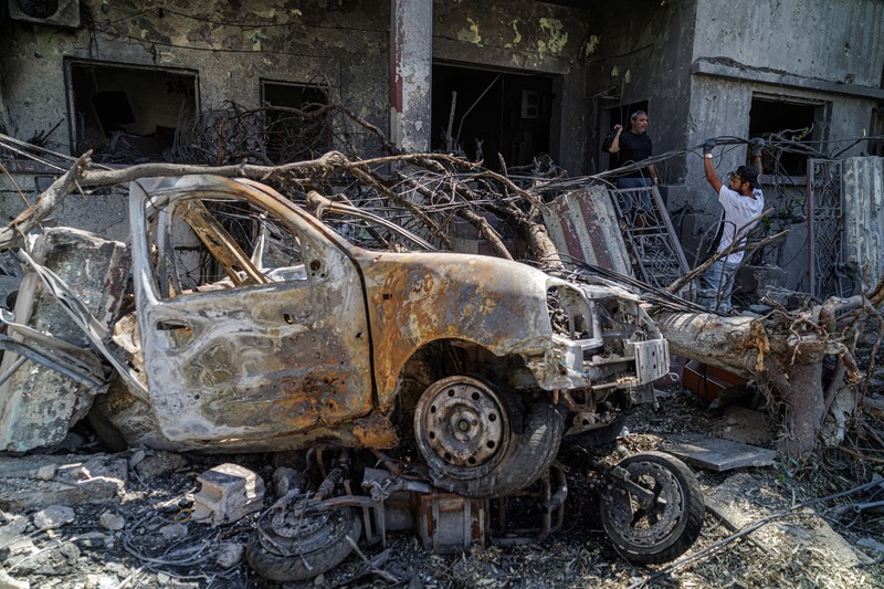 Youssef Fares, 90, whose home of more than 70 years was damaged in an Israeli airstrike, stands at the window of a hospital room where he has taken shelter, overlooking buildings damaged by Israeli strikes, following a deal between the United States and Iran, in Tyre, southern Lebanon, June 16, 2026. REUTERS/Zohra Bensemra.