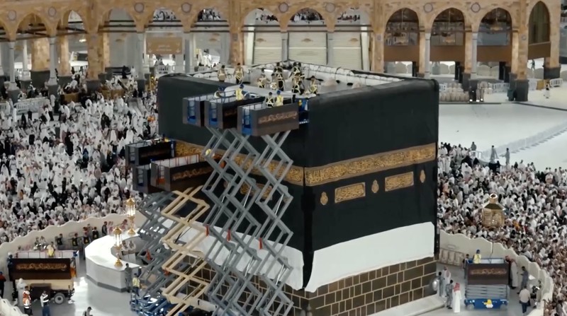 Sejumlah petugas mengganti Kiswah, kain sutra hitam yang menyelimuti Ka'bah di Masjidil Haram, Makkah, Arab Saudi, Senin (15/6/2026) malam waktu setempat, bertepatan dengan pergantian tahun Hijriah. (Tangkapan Layar Video Reuters/SAUDI PRESS AGENCY)