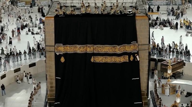 Sejumlah petugas mengganti Kiswah, kain sutra hitam yang menyelimuti Ka'bah di Masjidil Haram, Makkah, Arab Saudi, Senin (15/6/2026) malam waktu setempat, bertepatan dengan pergantian tahun Hijriah. (Tangkapan Layar Video Reuters/SAUDI PRESS AGENCY)