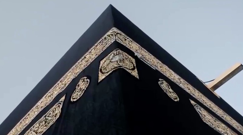 Sejumlah petugas mengganti Kiswah, kain sutra hitam yang menyelimuti Ka'bah di Masjidil Haram, Makkah, Arab Saudi, Senin (15/6/2026) malam waktu setempat, bertepatan dengan pergantian tahun Hijriah. (Tangkapan Layar Video Reuters/SAUDI PRESS AGENCY)