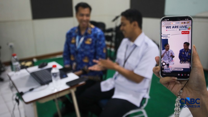 Petugas meberikan informasi kepada orang tua siswa pada posko pelayanan Sistem Penerimaan Murid Baru (SPMB) Tahun Ajaran 2026/2027 di SMAN 70 Jakarta, Rabu (17/6/2026). (CNBC Indonesia/Faisal Rahman)