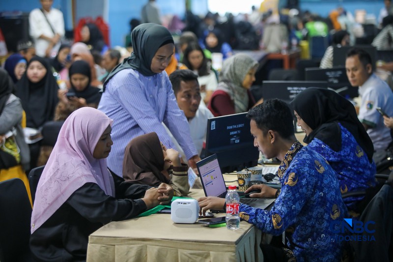 Petugas meberikan informasi kepada orang tua siswa pada posko pelayanan Sistem Penerimaan Murid Baru (SPMB) Tahun Ajaran 2026/2027 di SMAN 70 Jakarta, Rabu (17/6/2026). (CNBC Indonesia/Faisal Rahman)