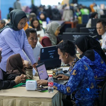 Petugas memberikan informasi kepada orang tua siswa pada posko pelayanan Sistem Penerimaan Murid Baru (SPMB) Tahun Ajaran 2026/2027 di SMAN 70 Jakarta, Rabu (17/6/2026). (CNBC Indonesia/Faisal Rahman)