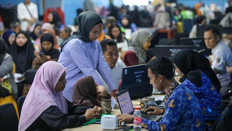 Petugas meberikan informasi kepada orang tua siswa pada posko pelayanan Sistem Penerimaan Murid Baru (SPMB) Tahun Ajaran 2026/2027 di SMAN 70 Jakarta, Rabu (17/6/2026). (CNBC Indonesia/Faisal Rahman)