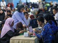 Petugas memberikan informasi kepada orang tua siswa pada posko pelayanan Sistem Penerimaan Murid Baru (SPMB) Tahun Ajaran 2026/2027 di SMAN 70 Jakarta, Rabu (17/6/2026). (CNBC Indonesia/Faisal Rahman)