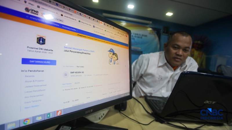 Petugas meberikan informasi kepada orang tua siswa pada posko pelayanan Sistem Penerimaan Murid Baru (SPMB) Tahun Ajaran 2026/2027 di SMAN 70 Jakarta, Rabu (17/6/2026). (CNBC Indonesia/Faisal Rahman)
