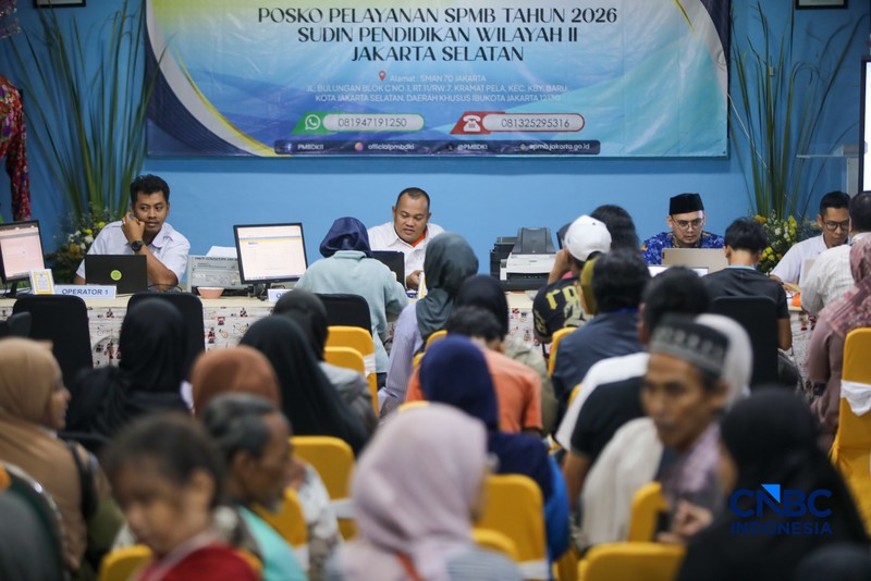 Petugas meberikan informasi kepada orang tua siswa pada posko pelayanan Sistem Penerimaan Murid Baru (SPMB) Tahun Ajaran 2026/2027 di SMAN 70 Jakarta, Rabu (17/6/2026). (CNBC Indonesia/Faisal Rahman)