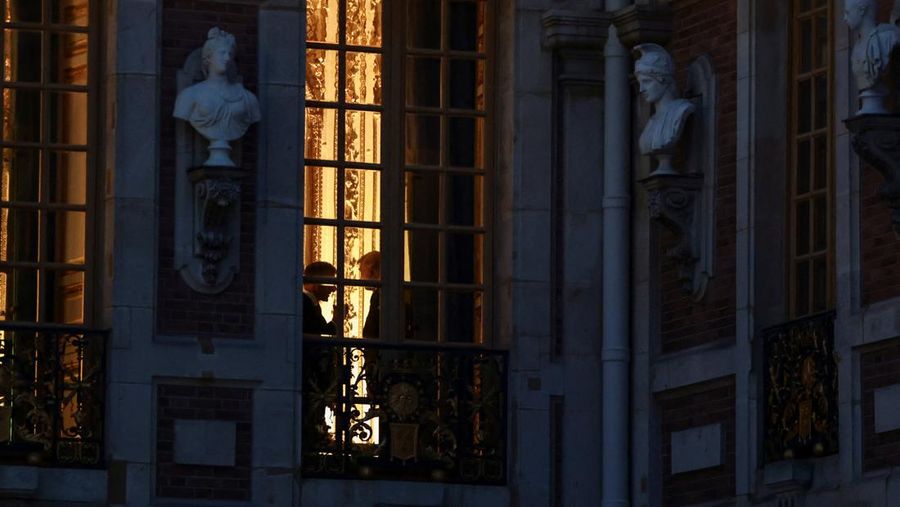 French President Emmanuel Macron and U.S. President Donald Trump are silhouetted behind a window ahead of a dinner commemorating the 250th anniversary of the United States' independence, at the Palace of Versailles, near Paris, France, June 17, 2026.