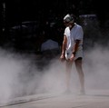 A man cools off in a water mister on the Place de la Republique in Paris as a heatwave hits a large part of France, June 18, 2026. REUTERS/Alice Sacco