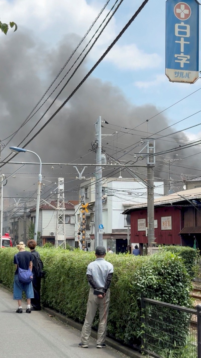 Smoke rises as students are evacuated from a primary school, after a fire broke out, in Kita city, Tokyo, Japan June 19, 2026, in this screengrab obtained from a social media video. @takanyo VIA X/via REUTERS  THIS IMAGE HAS BEEN SUPPLIED BY A THIRD PARTY. MANDATORY CREDIT. NO RESALES. NO ARCHIVES.     TPX IMAGES OF THE DAY        VERIFICATION: - Location confirmed from metadata, buildings, train track and signage that match archive and satellite imagery - Date confirmed by file data and local media report