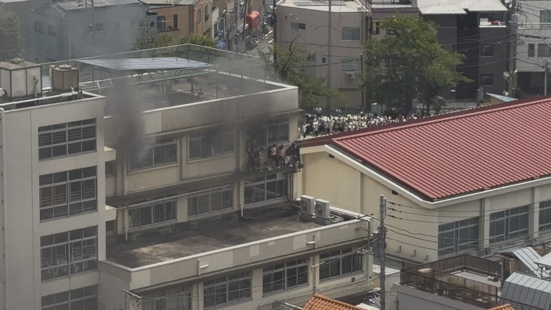 Smoke rises as students are evacuated from a primary school, after a fire broke out, in Kita city, Tokyo, Japan June 19, 2026, in this screengrab obtained from a social media video. @takanyo VIA X/via REUTERS  THIS IMAGE HAS BEEN SUPPLIED BY A THIRD PARTY. MANDATORY CREDIT. NO RESALES. NO ARCHIVES.     TPX IMAGES OF THE DAY        VERIFICATION: - Location confirmed from metadata, buildings, train track and signage that match archive and satellite imagery - Date confirmed by file data and local media report