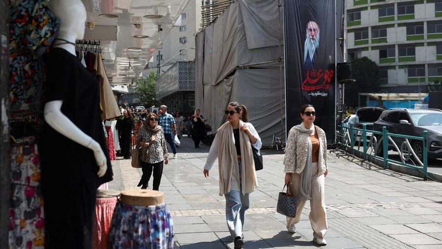 Orang-orang berjalan melewati spanduk dengan gambar mendiang Pemimpin Tertinggi Iran Ayatollah Ali Khamenei, di Teheran, Iran, 17 Juni 2026. (via REUTERS/Majid Asgaripour)
