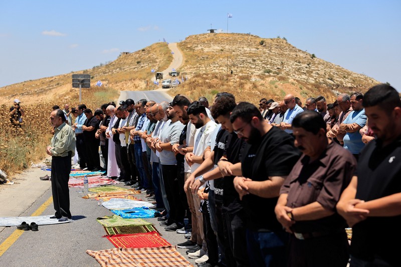 Warga Palestina menggelar aksi protes terhadap pembangunan permukiman baru Israel di sejumlah wilayah Tepi Barat yang diduduki, di dekat Hebron dan desa Deir Abu Mishal, wilayah dekat Ramallah, Jumat (19/6/2026). (REUTERS/Mussa Qawasma)