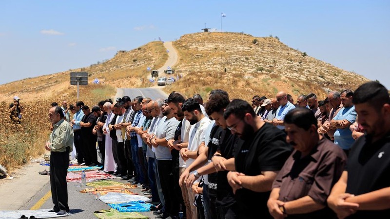 Warga Palestina menggelar aksi protes terhadap pembangunan permukiman baru Israel di sejumlah wilayah Tepi Barat yang diduduki, di dekat Hebron dan desa Deir Abu Mishal, wilayah dekat Ramallah, Jumat (19/6/2026). (REUTERS/Mussa Qawasma)