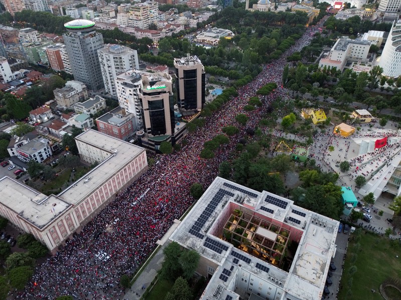 Warga di Albania melakukan demonstrasi menolak pembangunan resor terkait dengan keluarga Presiden Amerika Serikat (AS) Donald Trump, Minggu (21/6/2026). Demonstrasi yang dimulai hampir tiga minggu lalu itu semakin membesar. (REUTERS/Valdrin Xhemaj)