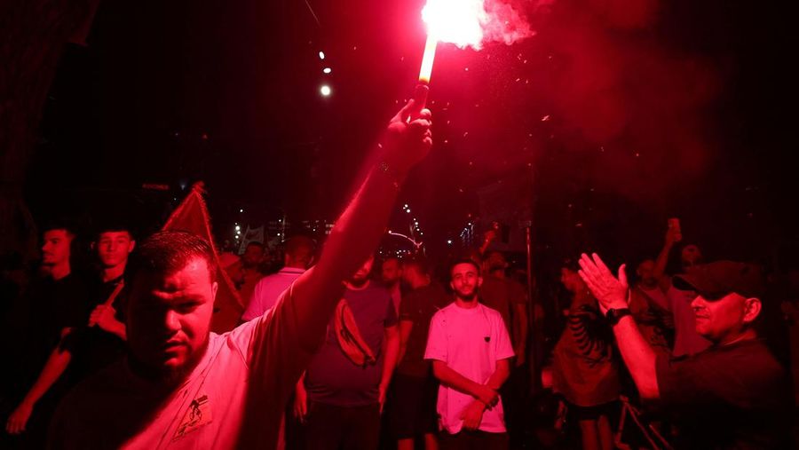 Warga di Albania melakukan demonstrasi menolak pembangunan resor terkait dengan keluarga Presiden Amerika Serikat (AS) Donald Trump, Minggu (21/6/2026). Demonstrasi yang dimulai hampir tiga minggu lalu itu semakin membesar. (REUTERS/Florion Goga)