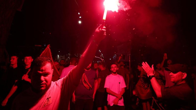Warga di Albania melakukan demonstrasi menolak pembangunan resor terkait dengan keluarga Presiden Amerika Serikat (AS) Donald Trump, Minggu (21/6/2026). Demonstrasi yang dimulai hampir tiga minggu lalu itu semakin membesar. (REUTERS/Florion Goga)