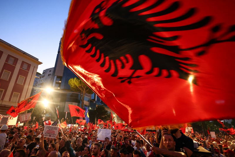 Warga di Albania melakukan demonstrasi menolak pembangunan resor terkait dengan keluarga Presiden Amerika Serikat (AS) Donald Trump, Minggu (21/6/2026). Demonstrasi yang dimulai hampir tiga minggu lalu itu semakin membesar. (REUTERS/Valdrin Xhemaj)