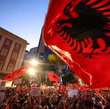 Warga di Albania melakukan demonstrasi menolak pembangunan resor terkait dengan keluarga Presiden Amerika Serikat (AS) Donald Trump, Minggu (21/6/2026). Demonstrasi yang dimulai hampir tiga minggu lalu itu semakin membesar. (REUTERS/Florion Goga)