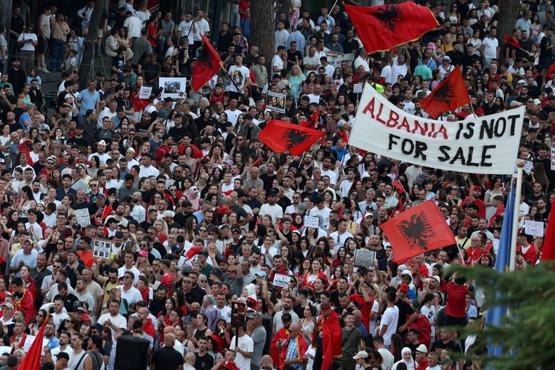 Warga di Albania melakukan demonstrasi menolak pembangunan resor terkait dengan keluarga Presiden Amerika Serikat (AS) Donald Trump, Minggu (21/6/2026). Demonstrasi yang dimulai hampir tiga minggu lalu itu semakin membesar. (REUTERS/Valdrin Xhemaj)