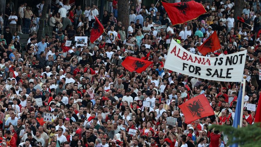 Warga di Albania melakukan demonstrasi menolak pembangunan resor terkait dengan keluarga Presiden Amerika Serikat (AS) Donald Trump, Minggu (21/6/2026). Demonstrasi yang dimulai hampir tiga minggu lalu itu semakin membesar. (REUTERS/Florion Goga)