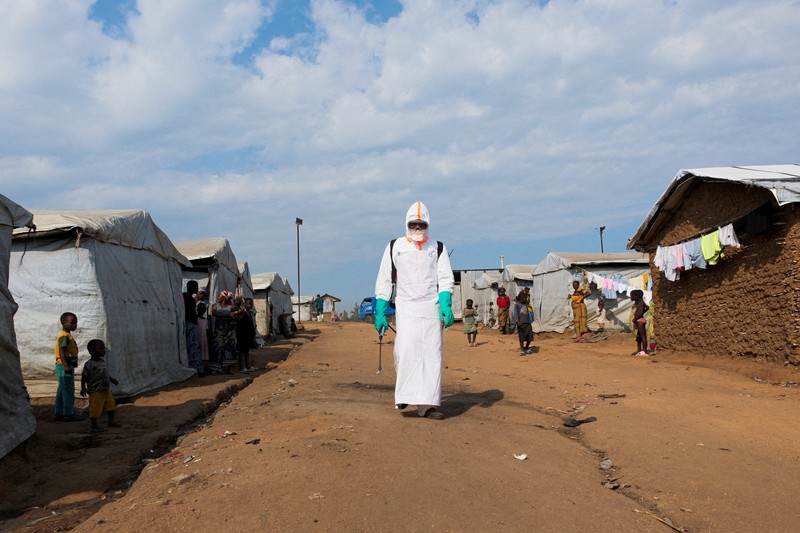 Petugas kesehatan dengan alat pelindung diri (APD) membawa peti mati korban yang diduga terinfeksi Ebola dari sebuah bangunan yang digunakan sebagai kamar mayat saat mereka mempersiapkan pemakaman di Pemakaman Nyamurongo, satu bulan setelah wabah dinyatakan, di Bunia, bagian timur Republik Demokratik Kongo, 18 Juni 2026. (REUTERS/Gradel Muyisa Mumbere)