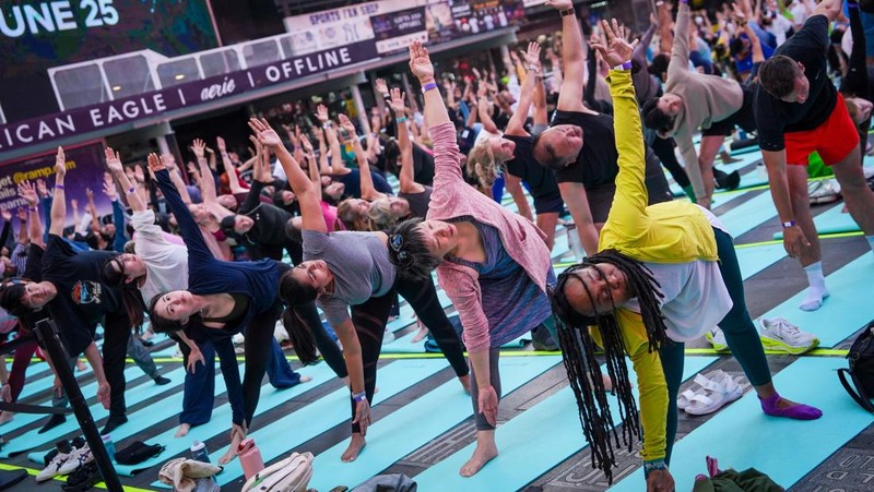 Para yogi mengikuti kelas yoga selama acara tahunan ke-24