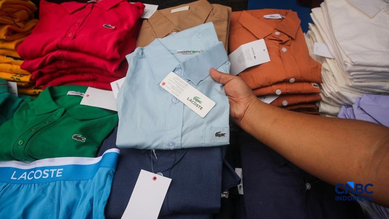 Petugas Direktorat Jenderal Kekayaan Intelektual (DJKI) menata produk menggunakan merek Lacoste tanpa hak saat konferensi pers di Jakarta, Senin (22/6/2026).