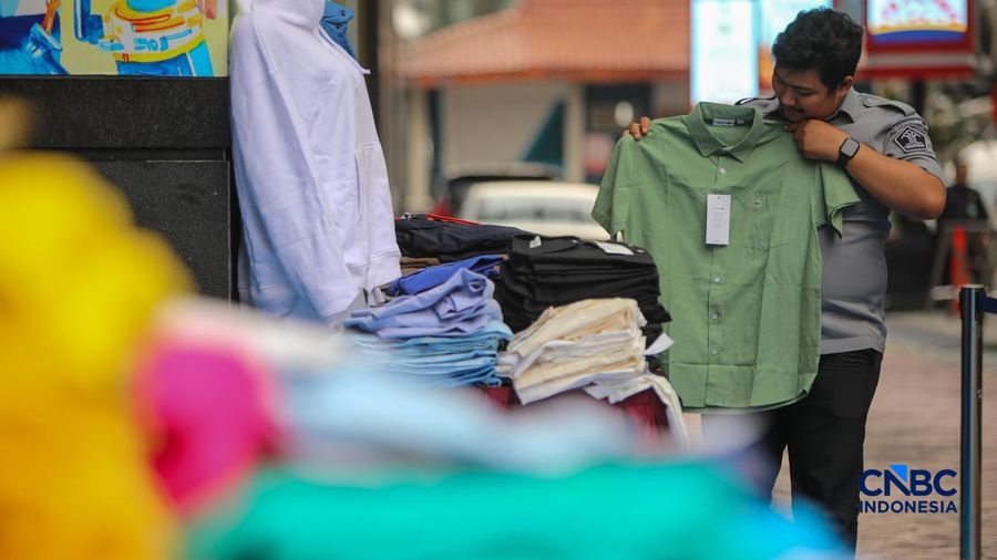Petugas Direktorat Jenderal Kekayaan Intelektual (DJKI) menata produk menggunakan merek Lacoste tanpa hak saat konferensi pers di Jakarta, Senin (22/6/2026). (CNBC Indonesia/Faisal Rahman)