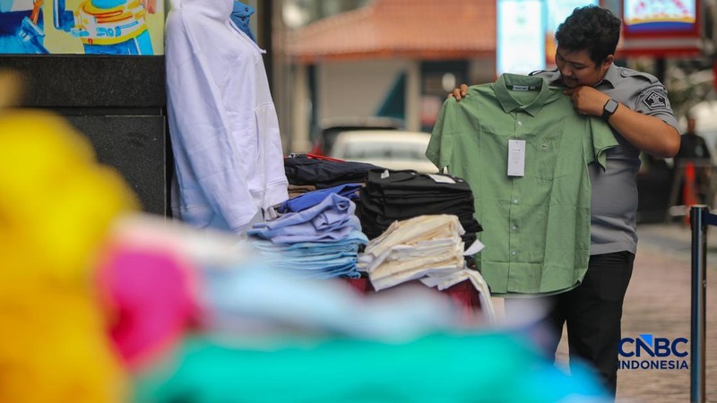 Petugas Direktorat Jenderal Kekayaan Intelektual (DJKI) menata produk menggunakan merek Lacoste tanpa hak saat konferensi pers di Jakarta, Senin (22/6/2026). (CNBC Indonesia/Faisal Rahman)