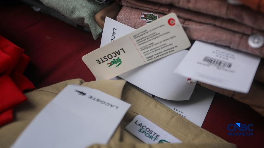Petugas Direktorat Jenderal Kekayaan Intelektual (DJKI) menata produk menggunakan merek Lacoste tanpa hak saat konferensi pers di Jakarta, Senin (22/6/2026).