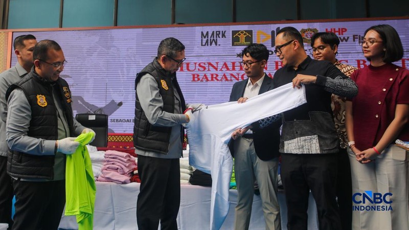 Petugas Direktorat Jenderal Kekayaan Intelektual (DJKI) menata produk menggunakan merek Lacoste tanpa hak saat konferensi pers di Jakarta, Senin (22/6/2026).