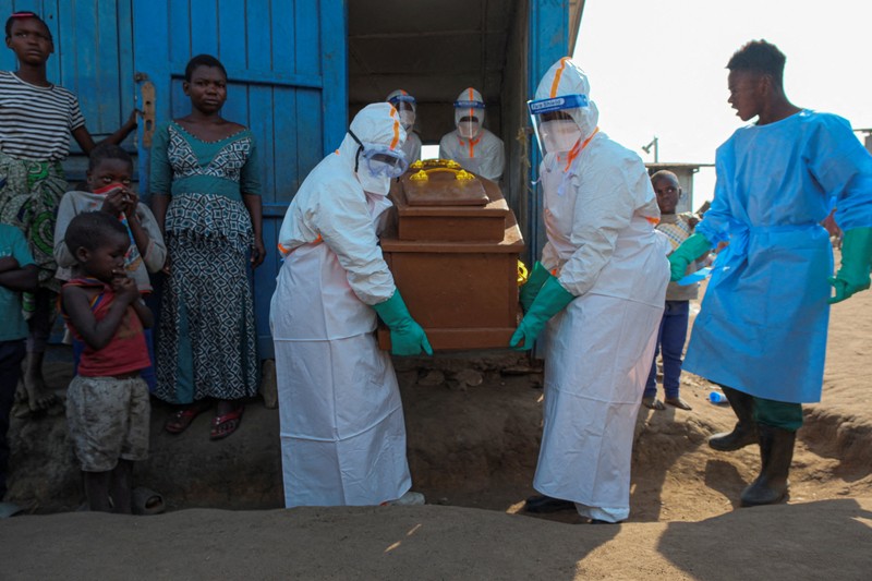 Petugas kesehatan dengan alat pelindung diri (APD) membawa peti mati korban yang diduga terinfeksi Ebola dari sebuah bangunan yang digunakan sebagai kamar mayat saat mereka mempersiapkan pemakaman di Pemakaman Nyamurongo, satu bulan setelah wabah dinyatakan, di Bunia, bagian timur Republik Demokratik Kongo, 18 Juni 2026. (REUTERS/Gradel Muyisa Mumbere)