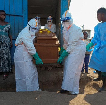 Petugas kesehatan dengan alat pelindung diri (APD) membawa peti mati korban yang diduga terinfeksi Ebola dari sebuah bangunan yang digunakan sebagai kamar mayat saat mereka mempersiapkan pemakaman di Pemakaman Nyamurongo, satu bulan setelah wabah din