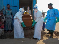 Petugas kesehatan dengan alat pelindung diri (APD) membawa peti mati korban yang diduga terinfeksi Ebola dari sebuah bangunan yang digunakan sebagai kamar mayat saat mereka mempersiapkan pemakaman di Pemakaman Nyamurongo, satu bulan setelah wabah din
