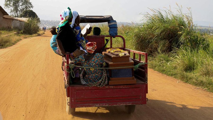 Warga kamp pengungsi Kigonze duduk di atas becak di samping peti mati kerabat mereka yang diduga meninggal karena Ebola saat mereka menuju pemakaman di Pemakaman Nyamurongo, satu bulan setelah wabah Ebola dinyatakan, di Bunia, bagian timur Republik Demokratik Kongo, 18 Juni 2026.
