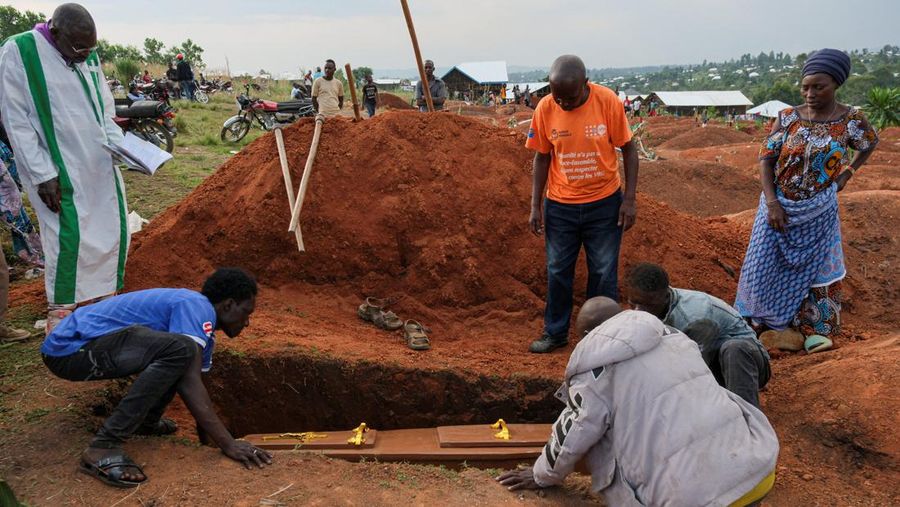 Warga kamp pengungsi Kigonze menurunkan peti mati selama upacara pemakaman seseorang yang diduga meninggal karena Ebola, di Pemakaman Nyamurongo, satu bulan setelah wabah Ebola dinyatakan, di Bunia, bagian timur Republik Demokratik Kongo, 18 Juni 2026.