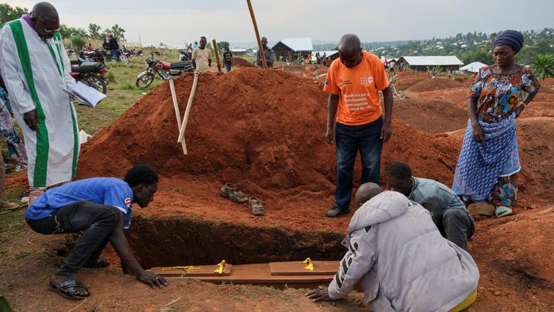 Warga kamp pengungsi Kigonze menurunkan peti mati selama upacara pemakaman seseorang yang diduga meninggal karena Ebola, di Pemakaman Nyamurongo, satu bulan setelah wabah Ebola dinyatakan, di Bunia, bagian timur Republik Demokratik Kongo, 18 Juni 2026.